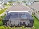 Aerial view of the screened-in patio with a hot tub and lounge seating at 32231 Conchshell Sail St, Wesley Chapel, FL 33545