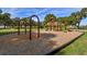 Community playground with swings, slides, and climbing structures on a mulch base, surrounded by lush landscaping at 32231 Conchshell Sail St, Wesley Chapel, FL 33545