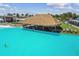 Eye-catching lagoon with a swim-up tiki bar and lounge seating with turquoise water at 32231 Conchshell Sail St, Wesley Chapel, FL 33545