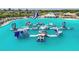Fun water park with various inflatable play structures floating on the expansive, clear turquoise lagoon at 32231 Conchshell Sail St, Wesley Chapel, FL 33545