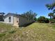 A view of the expansive backyard of the house and the exterior back of the house on a sunny day at 3308 E Frierson Ave, Tampa, FL 33610