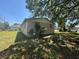 A side yard view of a single story home with boarded up windows, set back in the yard at 3308 E Frierson Ave, Tampa, FL 33610