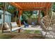 Inviting backyard with pergola, swing bench, hanging chair, fire pit and seating at 341 Wertz Dr, Largo, FL 33771