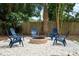 Relaxing backyard space features Adirondack chairs around a stone fire pit at 341 Wertz Dr, Largo, FL 33771