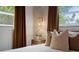 Bedroom featuring a nightstand and window with brown curtains, natural woven lamp at 341 Wertz Dr, Largo, FL 33771
