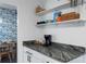Elegant kitchen with open shelving, granite countertop, and a view into the dining area at 341 Wertz Dr, Largo, FL 33771