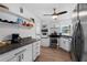 Stylish kitchen featuring stainless steel appliances, granite counters, white cabinets, and wood-look floors at 341 Wertz Dr, Largo, FL 33771