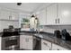 Close-up view of the kitchen with granite counters, stainless steel appliances, and a sink overlooking the backyard at 341 Wertz Dr, Largo, FL 33771
