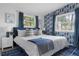 Inviting primary bedroom with large windows, shell-themed wallpaper, and elegant blue accents at 341 Wertz Dr, Largo, FL 33771