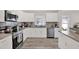 Well-equipped kitchen with stainless steel appliances, sleek white cabinets, and stylish tile backsplash at 3613 21St S Ave, St Petersburg, FL 33711