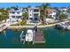 Aerial view showcasing the home's pool, dock, and waterfront location, complemented by lush landscaping and neighboring properties at 443 18Th Ave, Indian Rocks Beach, FL 33785