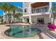 Inviting backyard with a pool, spa, outdoor seating, and a charming swing set against a backdrop of lush palms at 443 18Th Ave, Indian Rocks Beach, FL 33785