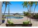 Relaxing backyard scene with a pool, waterfront view, swing, and lush tropical plants, creating a serene oasis at 443 18Th Ave, Indian Rocks Beach, FL 33785