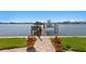 Picturesque waterfront dock featuring a boat lift, wooden walkway, and vibrant flowers, ideal for boating enthusiasts at 443 18Th Ave, Indian Rocks Beach, FL 33785