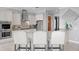 Kitchen featuring stainless steel appliances, kitchen island with white stools and modern decor at 443 18Th Ave, Indian Rocks Beach, FL 33785