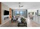 Open concept living room with a stone fireplace, TV, and access to the lanai with water views at 443 18Th Ave, Indian Rocks Beach, FL 33785