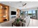 Modern living room with a stone accent wall, fireplace, and sliding glass doors to a waterfront view at 443 18Th Ave, Indian Rocks Beach, FL 33785