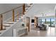 Open-concept living room with modern staircase, fireplace, and waterfront views at 443 18Th Ave, Indian Rocks Beach, FL 33785
