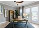 Bright home office features a wood desk, ceiling fan, and balcony access overlooking the outdoor scenery at 443 18Th Ave, Indian Rocks Beach, FL 33785