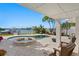 Inviting pool and spa offer relaxation with waterfront views and swaying palms, complemented by comfortable outdoor seating at 443 18Th Ave, Indian Rocks Beach, FL 33785