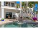 Beautiful pool and spa with brick surround, accented by vibrant flowers and a staircase leading to upper floors at 443 18Th Ave, Indian Rocks Beach, FL 33785