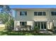 Two-story home with light-colored stucco, trimmed hedges, and an awning over the patio at 4560 Overlook Ne Dr # 168, St Petersburg, FL 33703