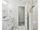 Bright bathroom with a white vanity, open shower, and a door leading to another room at 48 Bishop Creek Dr, Safety Harbor, FL 34695