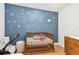 Cozy Bedroom with a dark blue accent wall featuring whimsical space-themed decals and a wooden crib at 48 Bishop Creek Dr, Safety Harbor, FL 34695