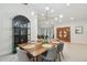 Bright dining room boasts a modern light fixture, sleek display cabinet and gorgeous hardwood floors at 48 Bishop Creek Dr, Safety Harbor, FL 34695