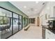 Bright living room with herringbone floors, mini-kitchenette, access to a screened porch and other rooms at 48 Bishop Creek Dr, Safety Harbor, FL 34695
