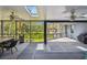 Screened porch featuring skylights and a dining area with views of the lush backyard at 48 Bishop Creek Dr, Safety Harbor, FL 34695