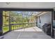 Charming screened porch showcasing serene backyard views and a grilling space at 48 Bishop Creek Dr, Safety Harbor, FL 34695