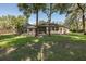 Wide view of the backyard featuring mature trees and screened in porch at 502 Creekside Ct, Safety Harbor, FL 34695