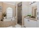 Bright bathroom with a soaking tub and glass shower, enhanced by natural light and neutral tones at 502 Creekside Ct, Safety Harbor, FL 34695