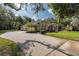 Spacious driveway leading to a well-maintained home surrounded by lush greenery and trees at 502 Creekside Ct, Safety Harbor, FL 34695