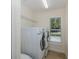 Clean laundry room with washer, dryer, shelving, and natural light at 502 Creekside Ct, Safety Harbor, FL 34695