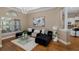 Living room with modern sofa, glass table, hardwood floors, and window, creating an inviting space at 502 Creekside Ct, Safety Harbor, FL 34695