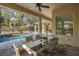 Covered patio with dining table, providing a seamless transition to the pool area at 502 Creekside Ct, Safety Harbor, FL 34695