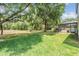 Expansive backyard featuring lush green grass, mature trees, and an enclosed pool area, creating a private oasis at 5109 Hartwell Loop, Land O Lakes, FL 34638