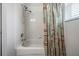 Bathroom featuring a tub with shower, white tile surround, and colorful shower curtain at 5109 Hartwell Loop, Land O Lakes, FL 34638