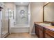 Bright bathroom with a glass shower, soaking tub with tile surround, and wooden vanity with a sink at 5109 Hartwell Loop, Land O Lakes, FL 34638