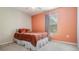 This comfortable bedroom includes an orange wall, ceiling fan and a window for natural light at 5109 Hartwell Loop, Land O Lakes, FL 34638