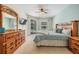 Bright bedroom showcasing a large bed, wooden dresser, sliding glass door with a view of the outdoor pool at 5109 Hartwell Loop, Land O Lakes, FL 34638