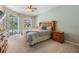 Cozy bedroom featuring a king bed, wooden furniture, and sliding doors leading to the outdoor pool area at 5109 Hartwell Loop, Land O Lakes, FL 34638
