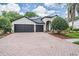 Charming single-story home with a three-car garage and a brick paver driveway at 5109 Hartwell Loop, Land O Lakes, FL 34638