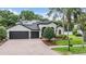Beautiful single-story house features a brick driveway, a three-car garage, and solar panels at 5109 Hartwell Loop, Land O Lakes, FL 34638