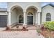 Charming front porch with elegant arches, brick walkway, stone accents, and well-manicured landscaping at 5109 Hartwell Loop, Land O Lakes, FL 34638