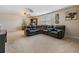 Spacious living room with a dark sectional couch, ceiling fan, and a large window letting in natural light at 5109 Hartwell Loop, Land O Lakes, FL 34638