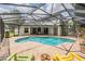 Inviting backyard with pool, brick patio, screened enclosure, and outdoor seating area at 5109 Hartwell Loop, Land O Lakes, FL 34638