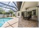 Covered patio area next to a pool with an outdoor dining set and a grill at 5109 Hartwell Loop, Land O Lakes, FL 34638